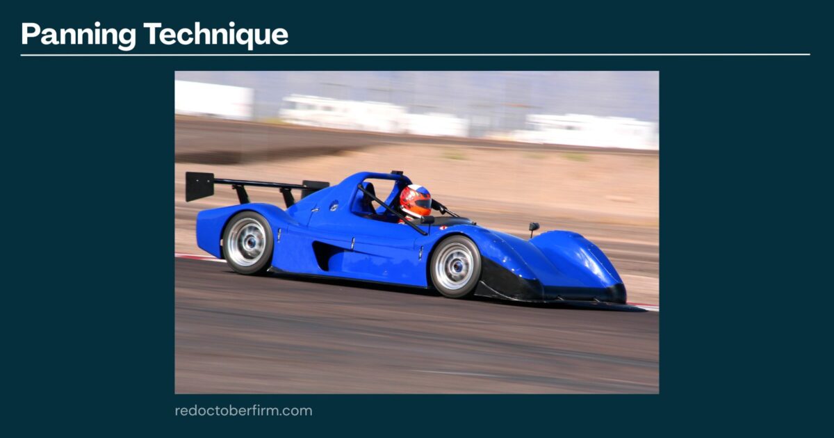 A Blue Race Car Speeds Along A Track, With A Blurred Background Demonstrating The Panning Photography Technique.