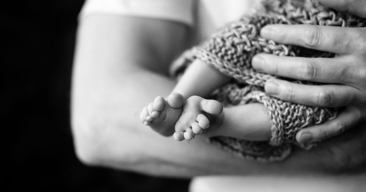 A Black And White Home Photography Of A Man Holding A Baby.