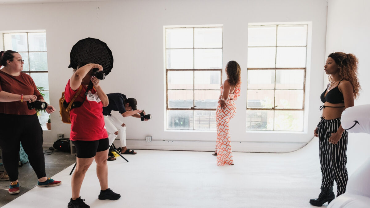 A Group Of People Join A Photography Group And Take Pictures In A Studio.