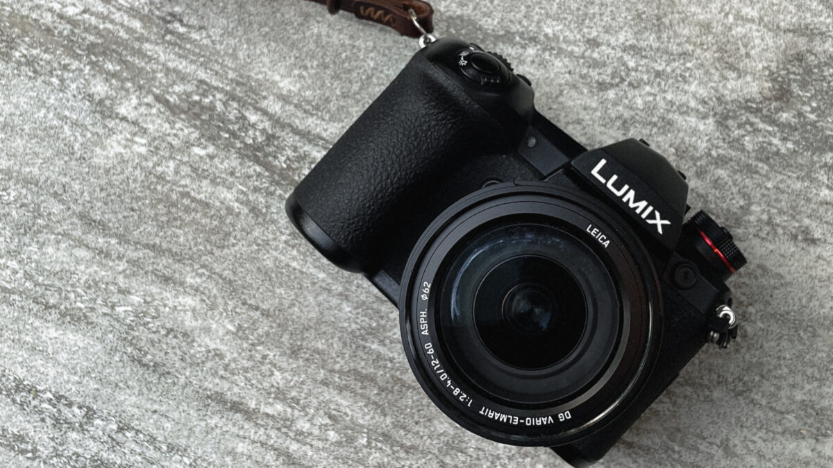 A Black Dslr Camera With A Strap Attached To It.