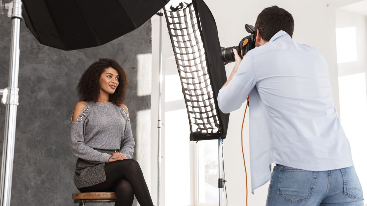 A Man Is Capturing The Perfect Indoor Photo Of A Woman With A Camera.