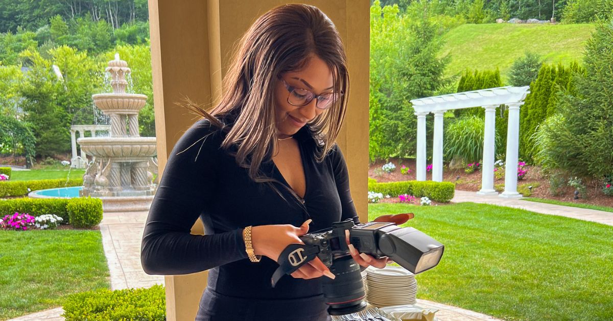 A Woman Capturing Photographs In Front Of A House, Demonstrating Photography For Beginners.