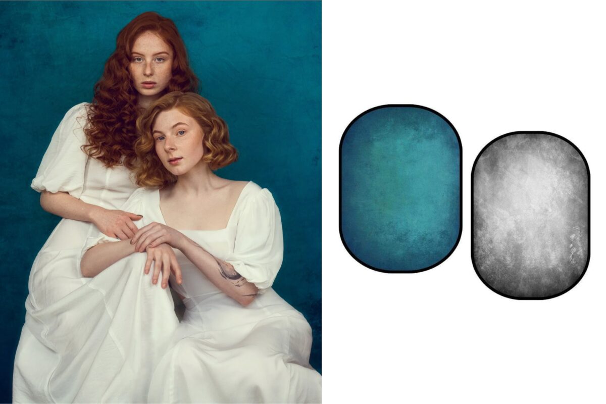 Two Women Are Posing In Front Of A Blue Photography Backdrop.