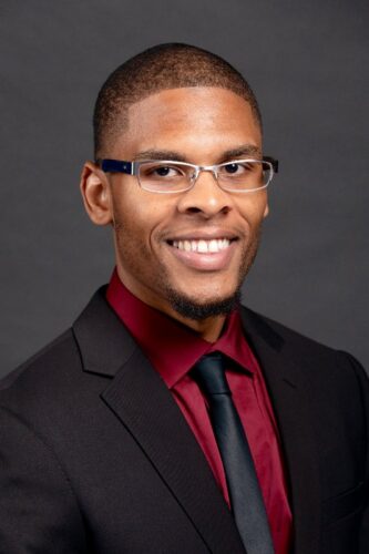 A Black Man In Glasses And A Red Tie.