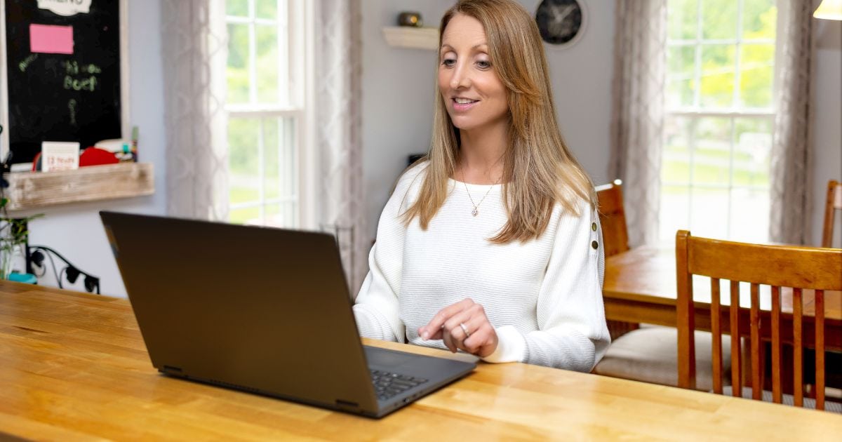 A Woman At Home Using Her Laptop For Photography.